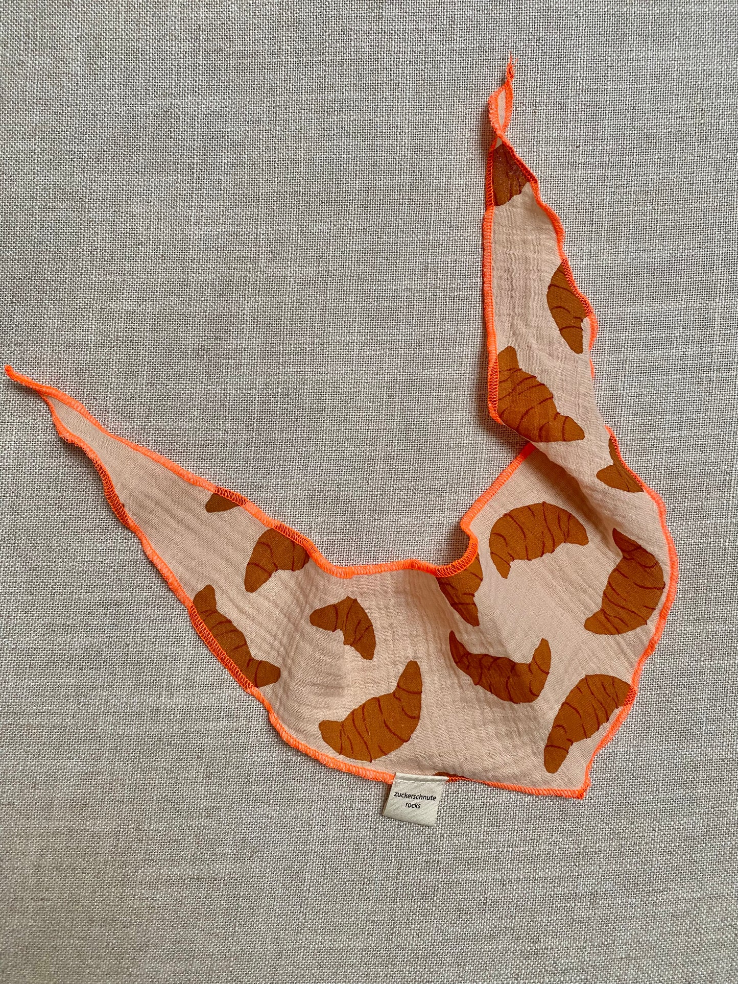 Dreieckstuch fuer hunde aus musselin in beige mit farbiger naht in orange. croissant print in braun